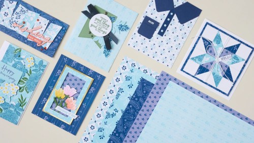 Various handcrafted greeting cards and patterned paper in shades of blue, featuring floral designs, stars, and a themed color palette.