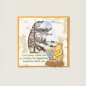 ウィニー・ザ・プーが描かれたカードで、森林の風景が背景にあり、"時々、幸福を探しに行くと、幸福が見つかります"と書かれている。