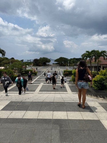 広場に向かって階段を下りる人々と曇り空の風景