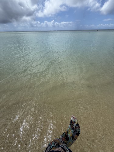 穏やかな海と足元の砂浜が映る風景